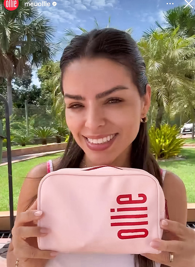 Mulher sorridente segura uma necessaire rosa da Ollie