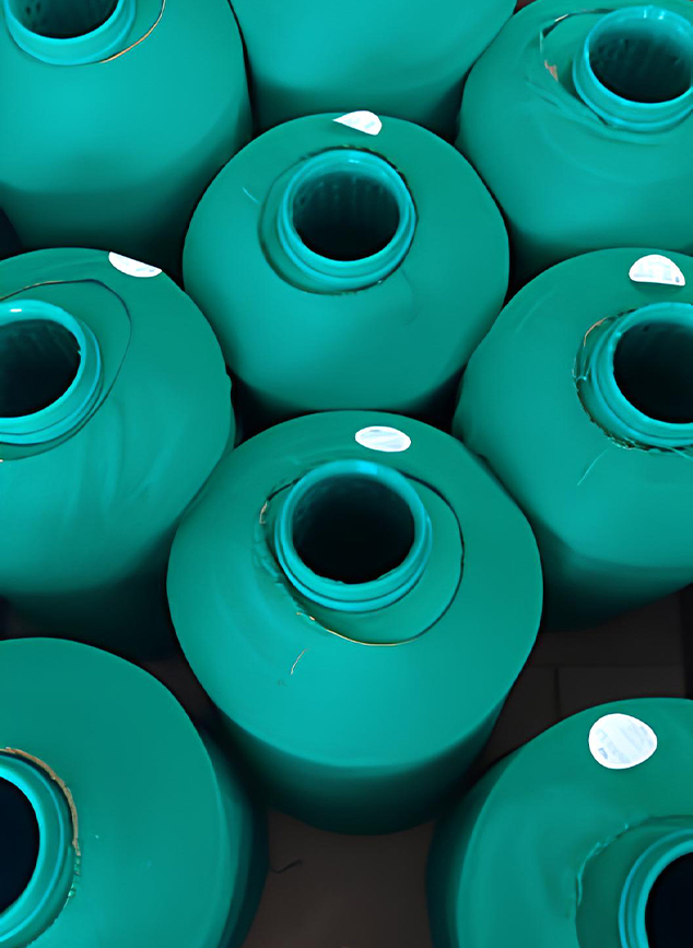 Carretéis de fio têxtil verde-turquesa vistos de cima