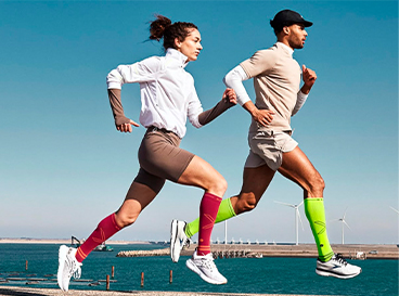 homem-mulher-correndo-corrida-esporte-meias-compressao-atividade-fisica-ao-ar-livre-mar
